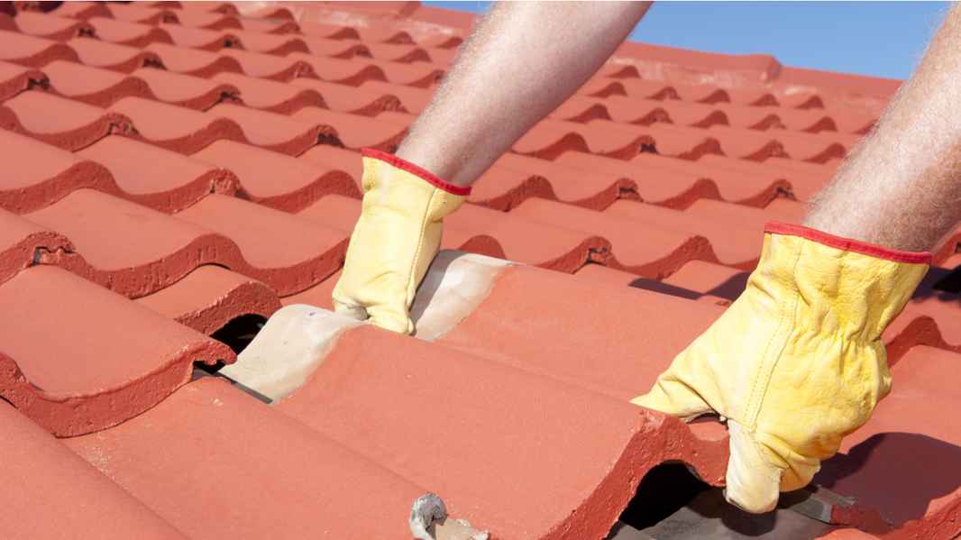 Homeowner installing a clay tile shingle roof